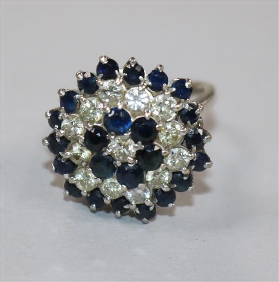 An 18ct white gold, sapphire and diamond cluster ring, size G.